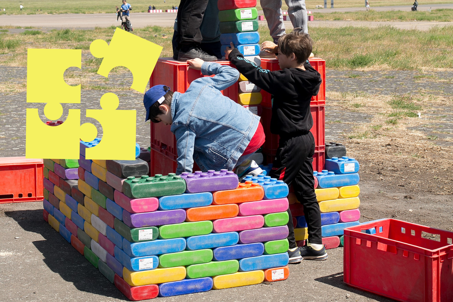 Kinder bauen mit großen bunten Noppensteinen, gelbes Icon für Bildungselemente