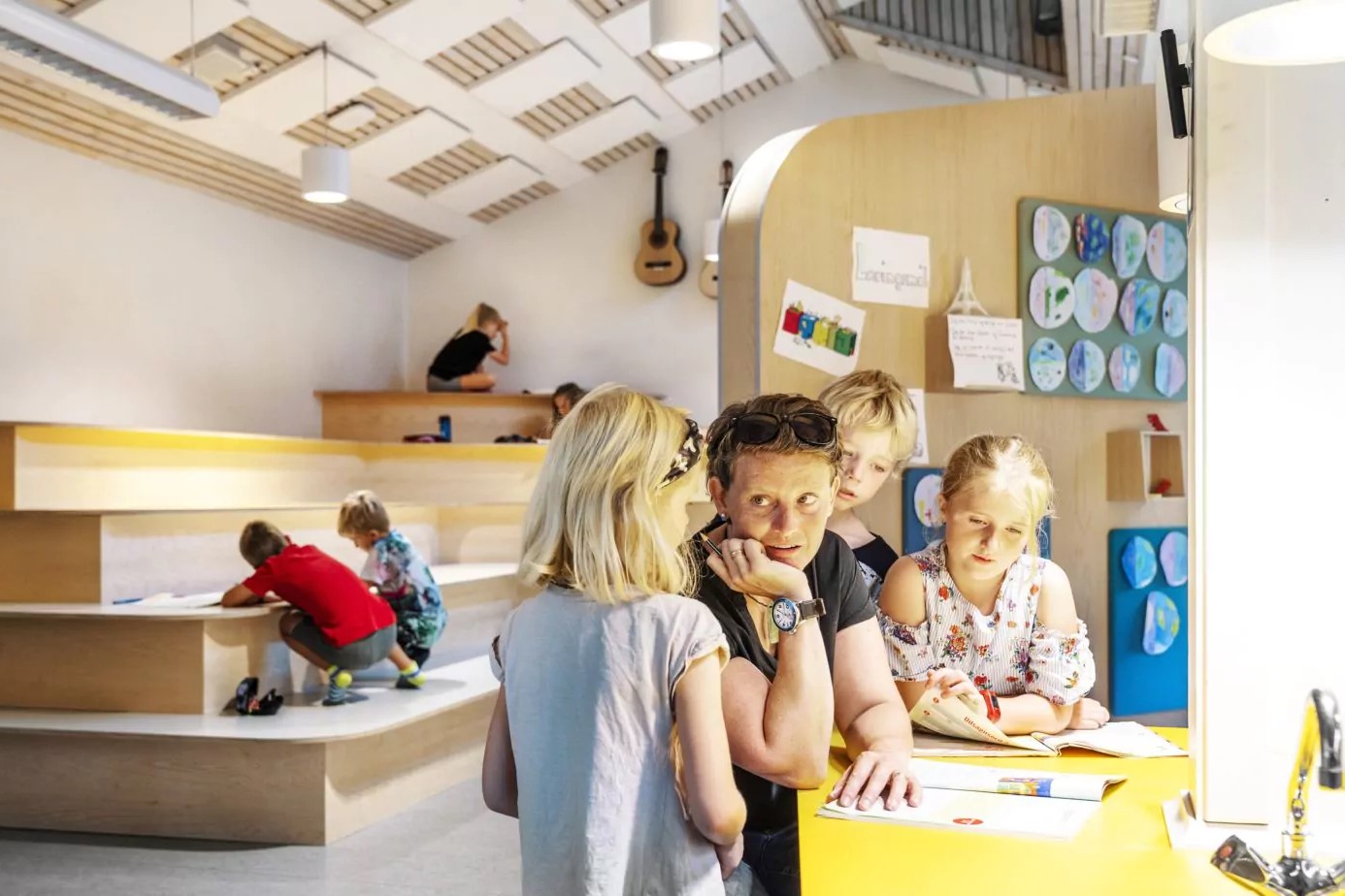 Kinder und Lehrkraft besprechen sich in schöner Lernumgebung