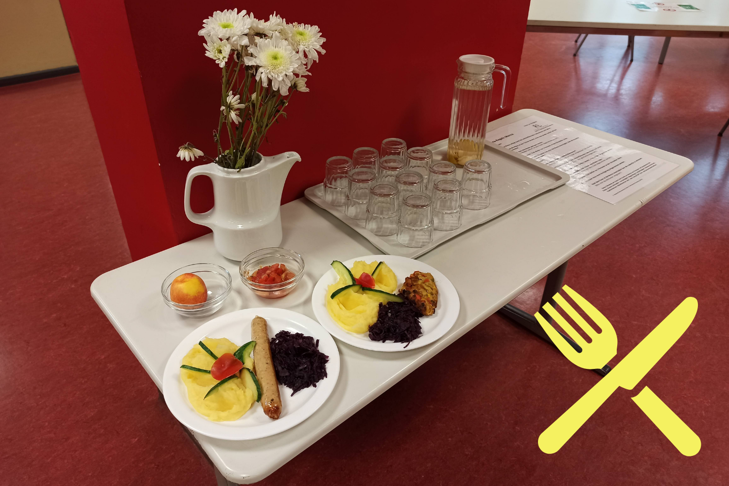 Musteressen mit Getränketablett und Blumenstrauß in einer Schulmensa der Schule am Königstor, Icon Schulische Verpflegung